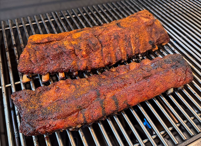 How long should ribs be cooked before grilling?